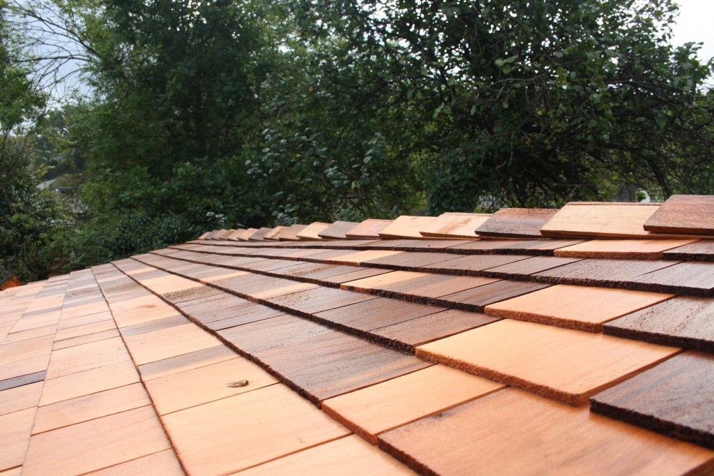 cedar shingles on a roof of a cedar tiled art studio installed into a garden