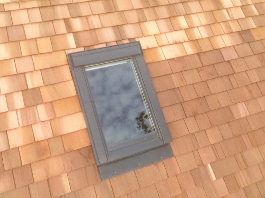 cedar shingles on a roof of a garden art studio with a roof window