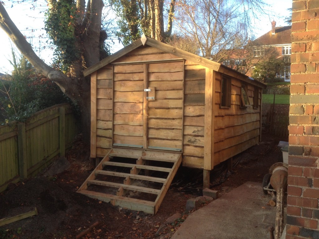 Waney edge shed on a raised platform with a pitched roof and very heavy duty