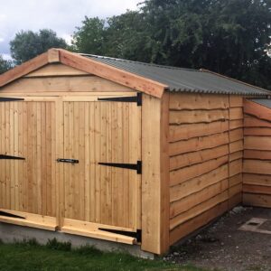 Timber garage with a tin roof and a adjoining log store