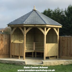 heavy duty timber corner arbour with slate roof and seating